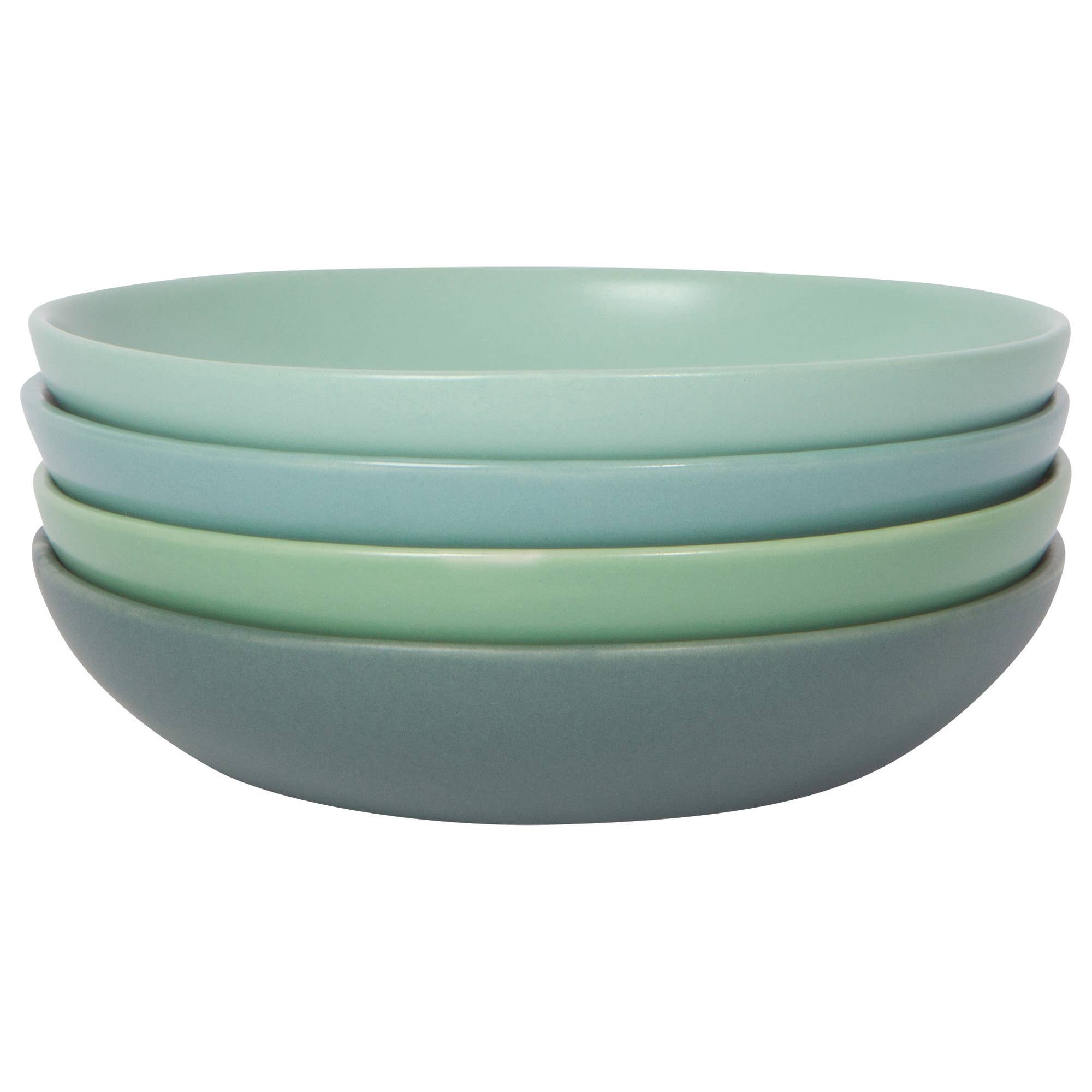 Set of four green ceramic bowls stacked on a white background