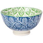 Ceramic bowl with blue and white floral pattern outside and green and white leaf pattern inside.