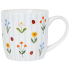 Mug with floral and ladybug and blue stripe design on a white background