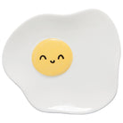 White sunny side up egg plate with a yellow smiley face in the center